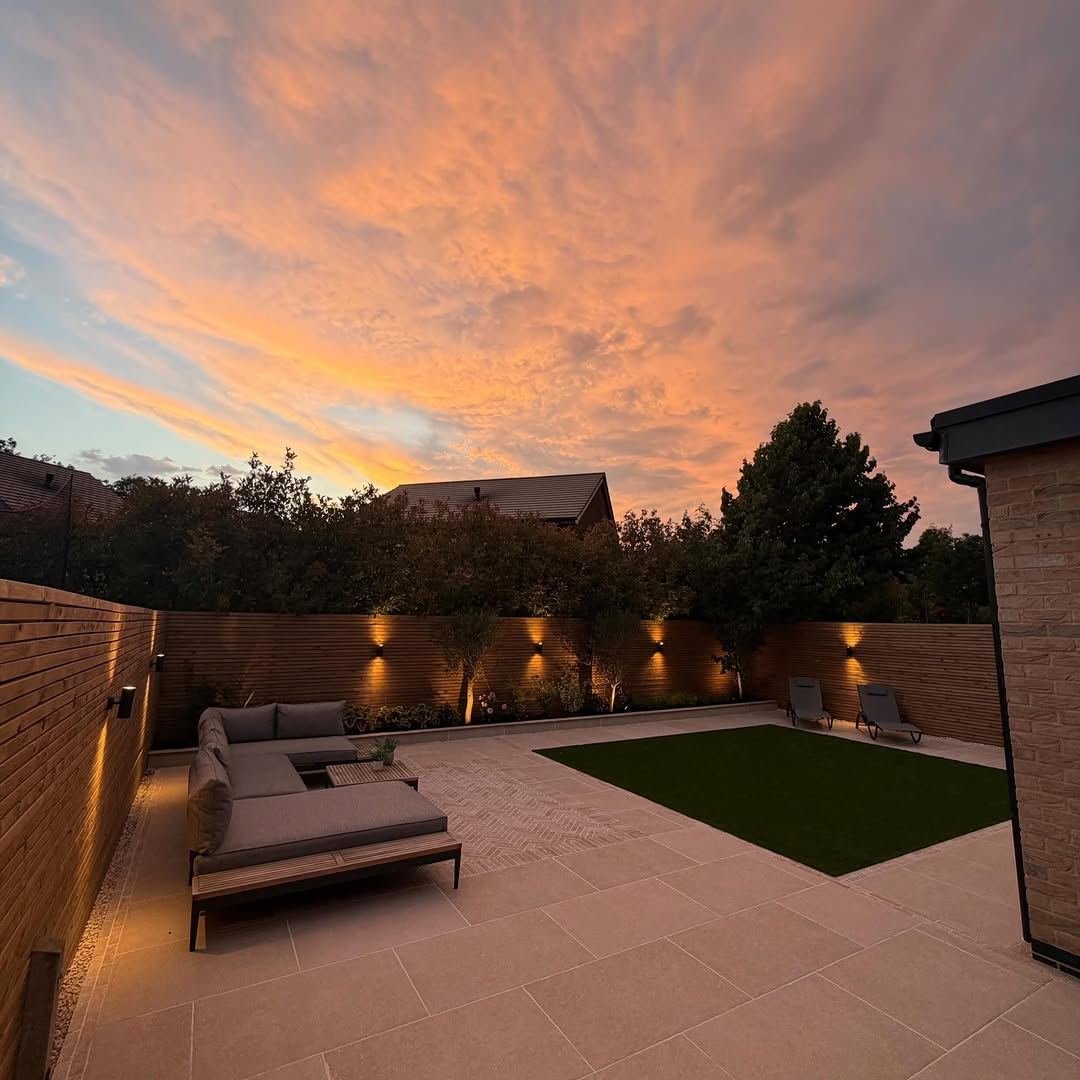 Porcelain patio with outdoor sofa and wall lights under an orange sunset
