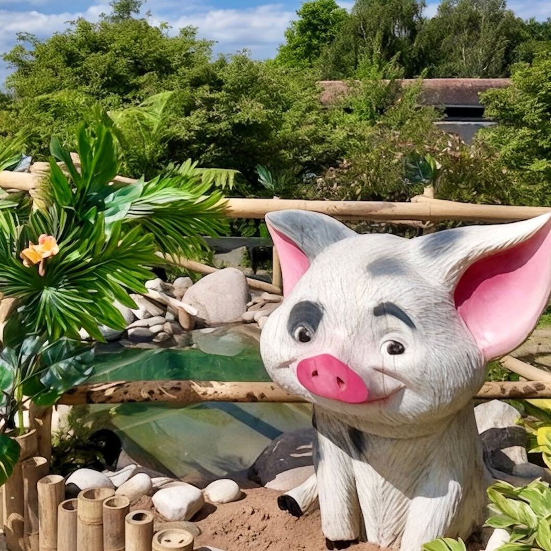 A Pua pig sculpture beside a tropical water feature in the hospice garden