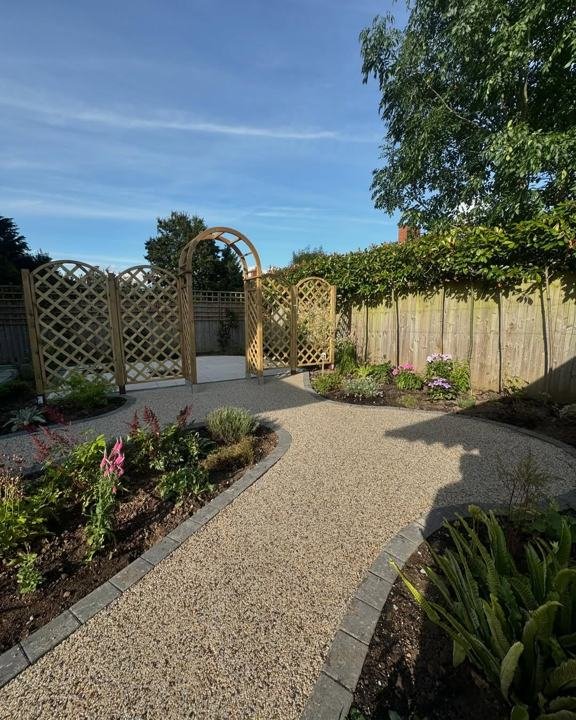 Resin path curving through planting to a timber arch