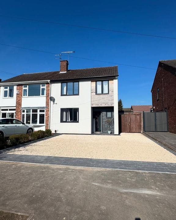 Gravel driveway with block edging in front of a semi-detached house