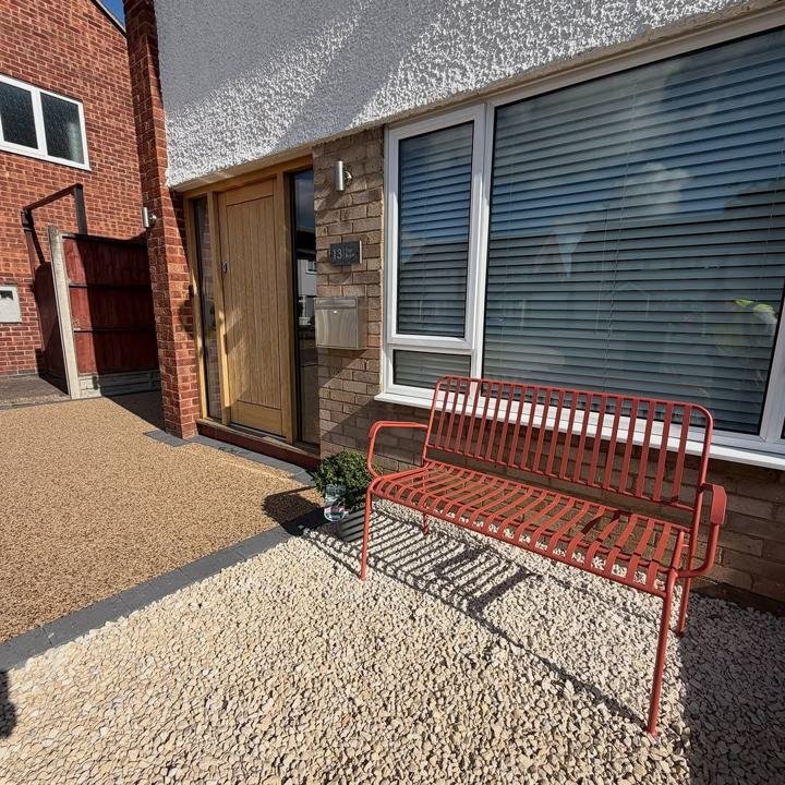 Small resin driveway with a red bench by the front door