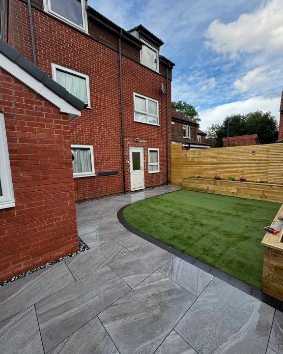 Porcelain paving and lawn along the side of a house