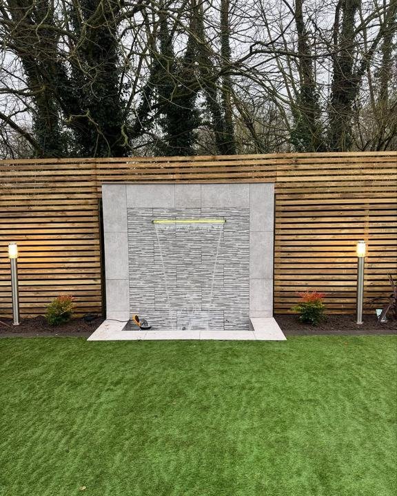 Slate water feature wall set into slatted fencing